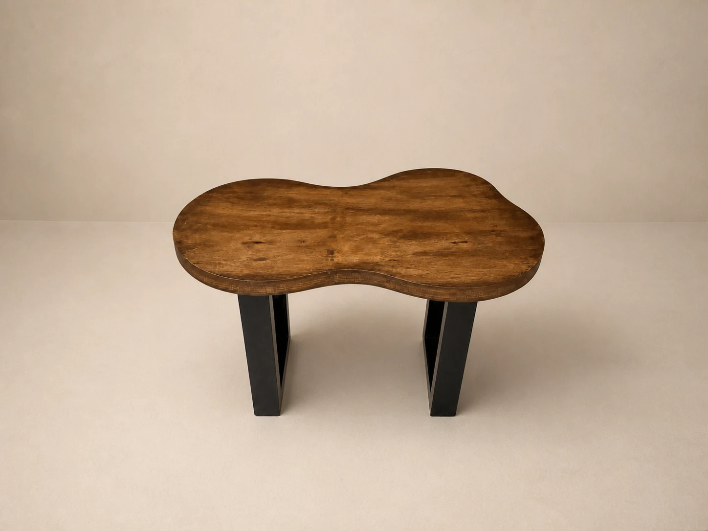 Mesa Cauce de forma orgánica con cubierta enchapada en parota y base negra